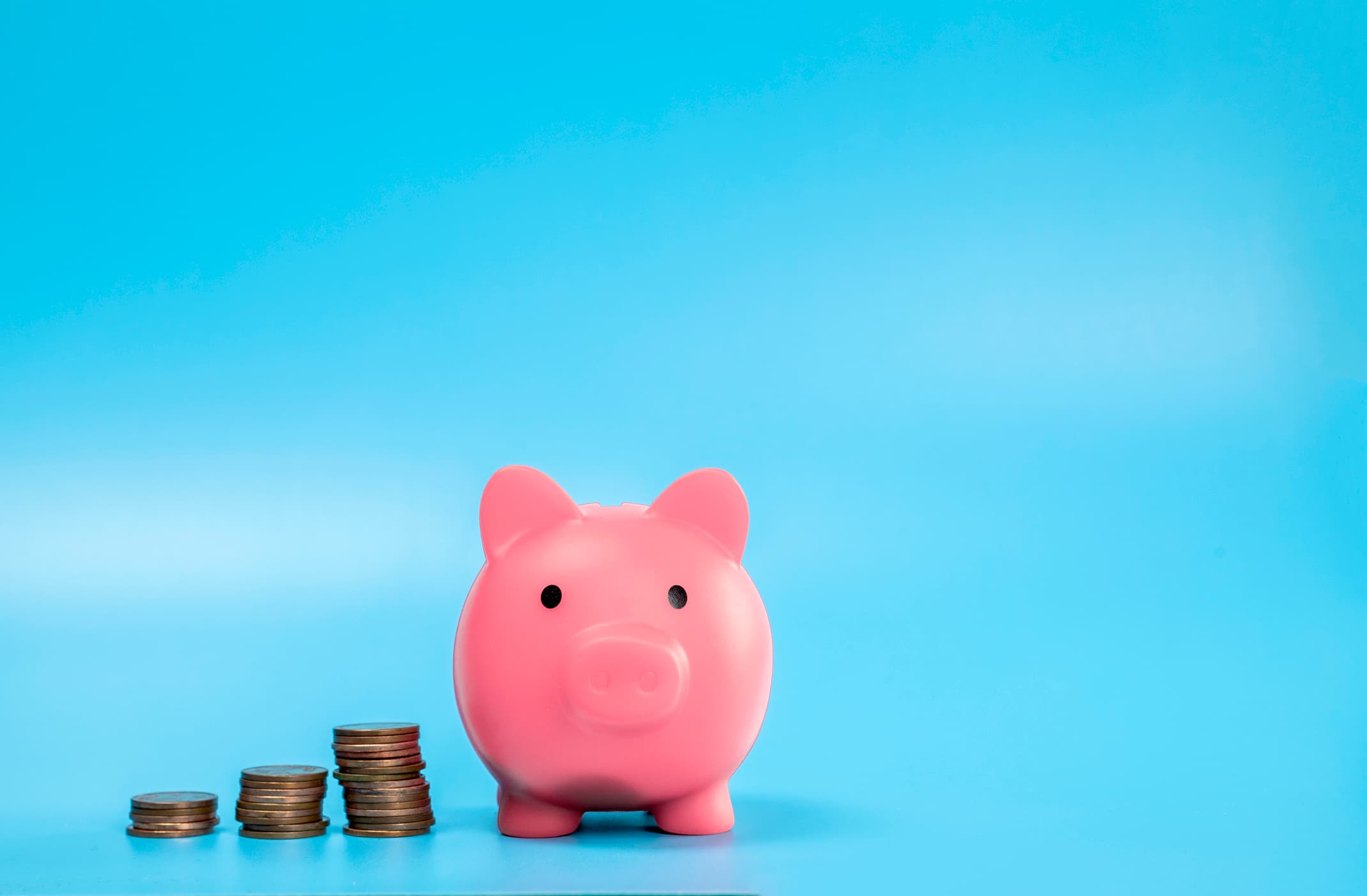 A piggy bank and growing stacks of coins